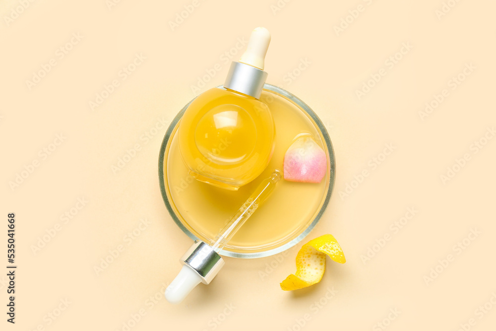 Bowl with bottle of citrus serum on color background