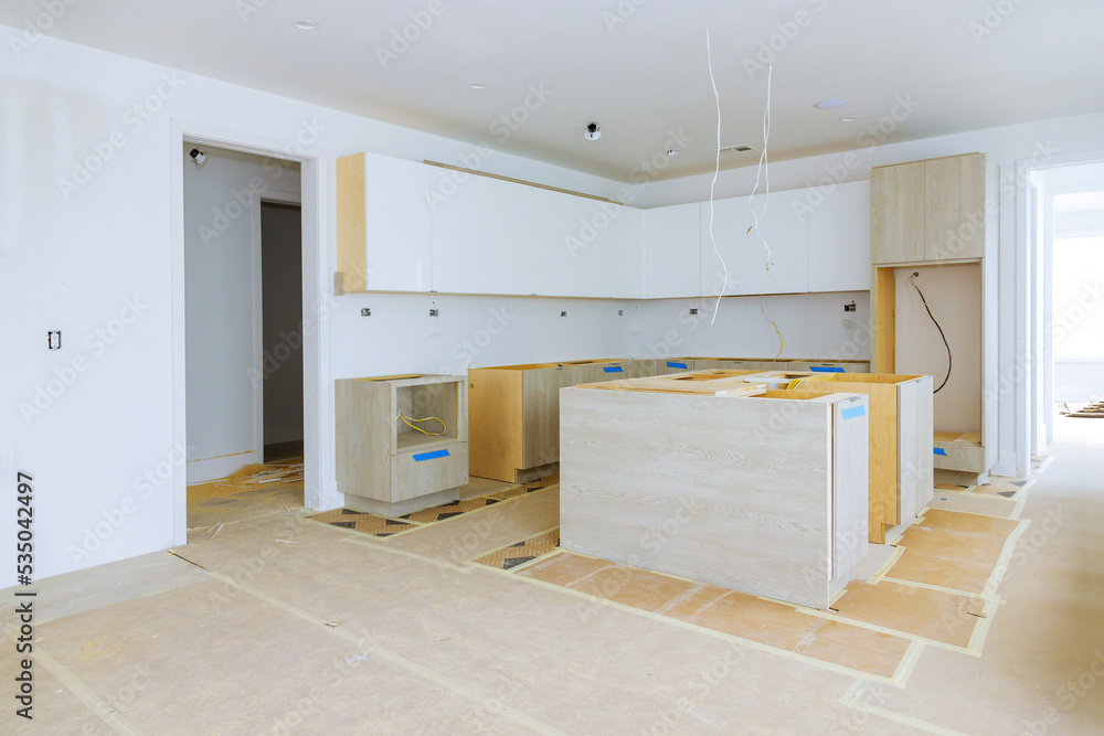 Installation of white kitchen cabinets in a newly constructed house ...