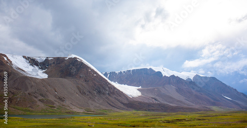 Beautiful nature of rocky mountains and peaks with glaciers. Unusual landscape of nature. Rocks on the background of the sky with clouds. Bad weather cyclone, rainy season, foggy day.