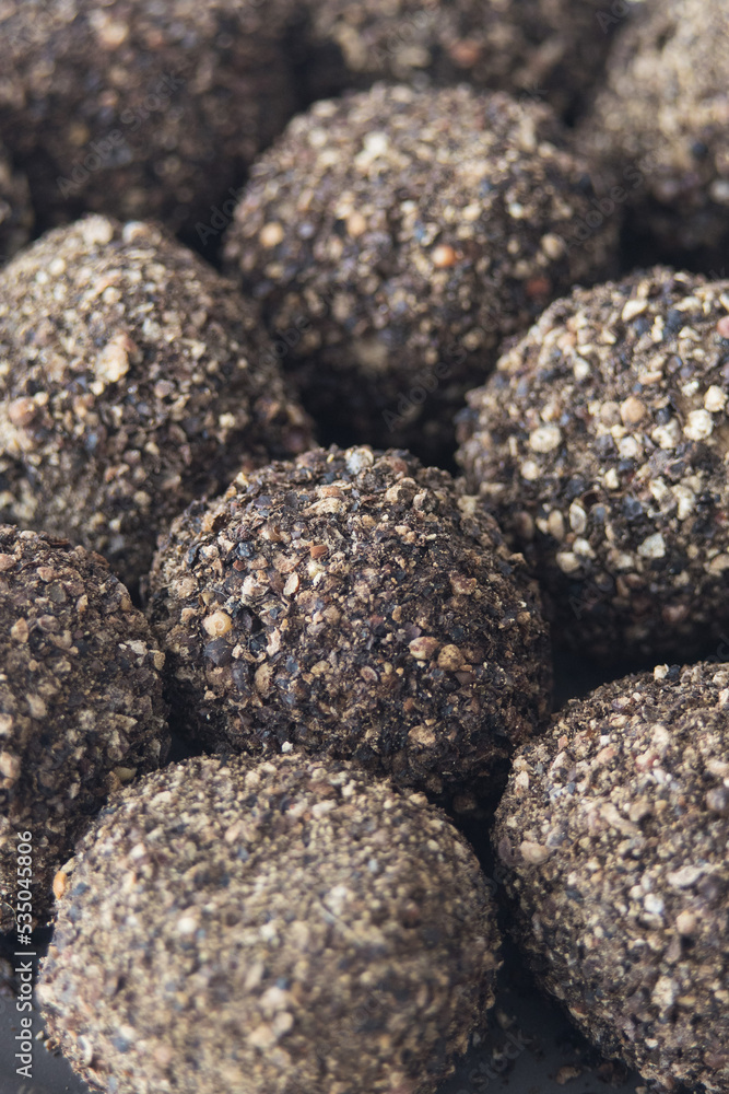 Small Swiss hard cheese balls Belper Knolle made from cow's milk in black pepper, selective focus, close-up Small Swiss hard cheese balls Belper Knolle made from cow's milk in black pepper, selective focus, close-up