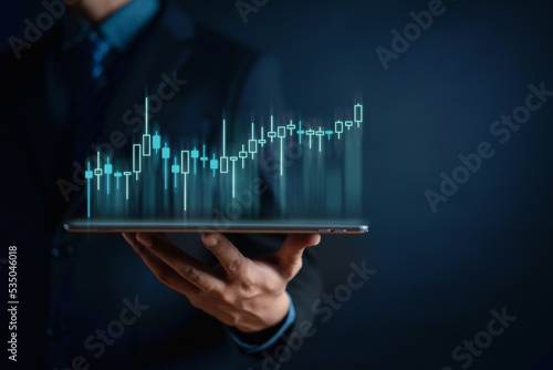 Businessman using tablet to analyze sales data trading and showing a growing virtual screen of statistics, graph and chart. Stock market business growth, planing and strategy concept.