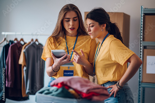 Couple of female volunteers working in community charity donation center