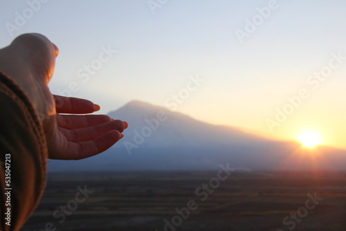 Person watching sunset. Hand showing sunset. Beautiful view.