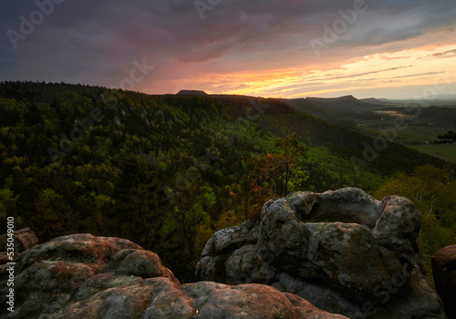 Sunset over the table mountains in Poland with rocky pond in the foreground
