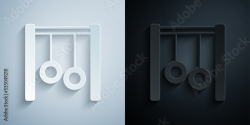 Paper cut Gymnastic rings icon isolated on grey and black background. Playground equipment with hanging rope with rings. Paper art style. Vector