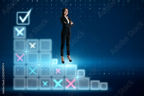 Attractive young european businesswoman standing on digital stairs to success on blue background. Futuristic goal achievement concept.