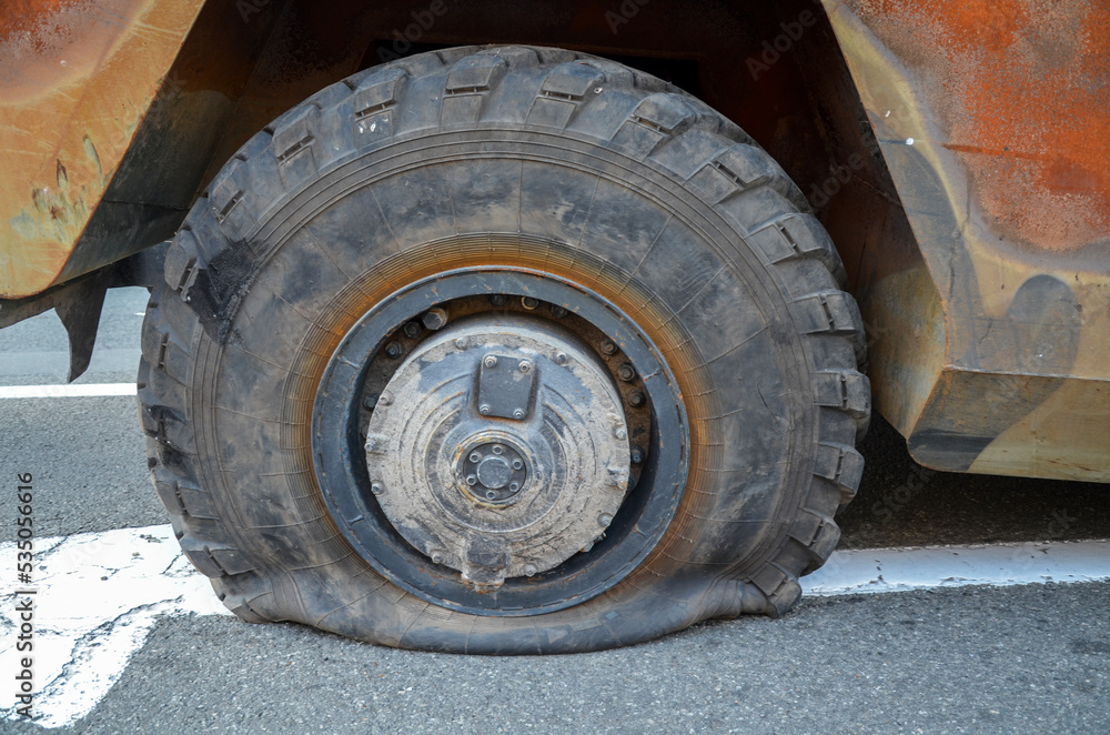 Close-up of vehicle with flat rear tire or puncture wheel on road