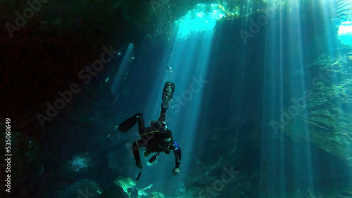 scuba diver exploring chac-mool cenote near cancun mexico photo