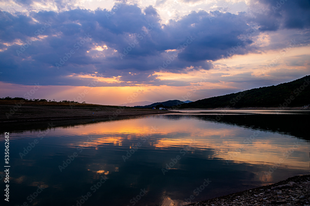 sunset with reflection over a dam