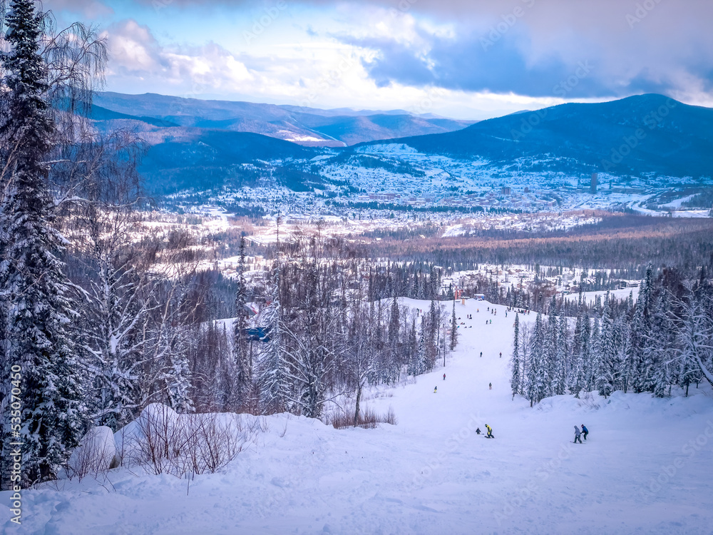 Winter landscape in Sheregesh ski resort in Russia, located in Mountain Shoriya, Siberia. Ski slopes and a view of the Sheregesh village