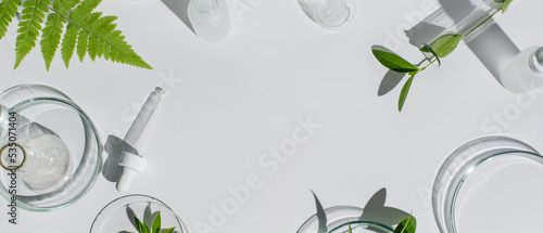Banner Laboratory glassware, Petri dishes,cosmetic glass bottles on white background. Natural medicine, cosmetic research, bio science, organic skin care products. Top view, flat lay, copy space. photo