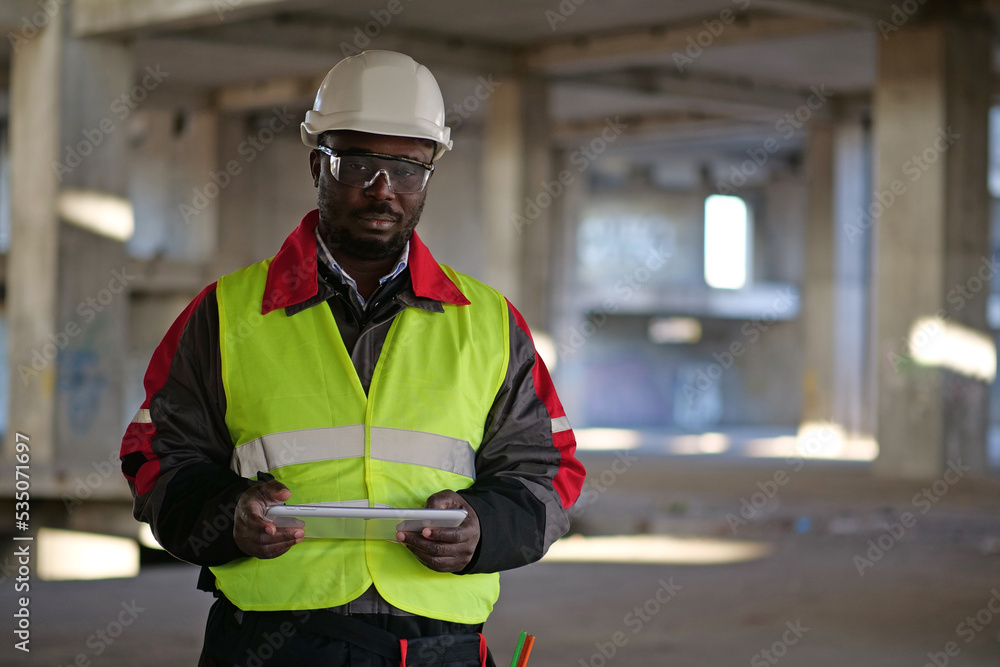 African american worker holds in hands tablet computer and looks at camera African american worker holds in hands tablet computer and looks at camera