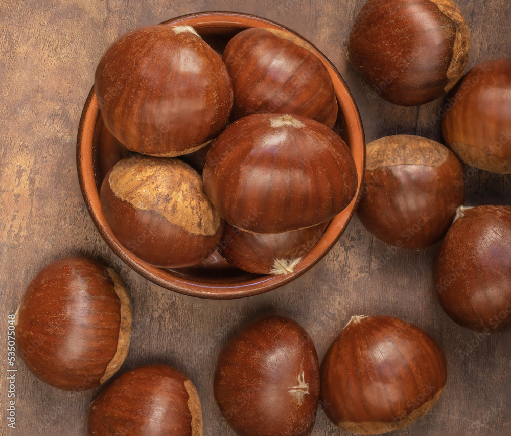 Edible chestnuts on dark rustic background. Horse chestnuts top view. Flat lay. Autumn food concept Edible chestnuts on dark rustic background. Horse chestnuts top view. Flat lay. Autumn food concept
