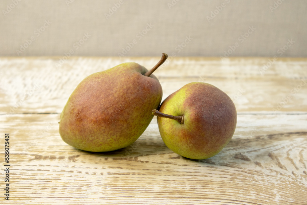 Green yellow pears in brown wooden bowl on rough wooden background, top view. Green yellow pears in brown wooden bowl on rough wooden background, top view.