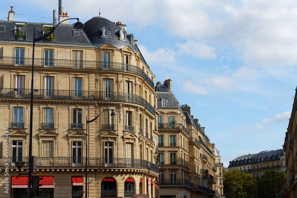 The facades of traditional French houses with typical balconies and windows. Paris.