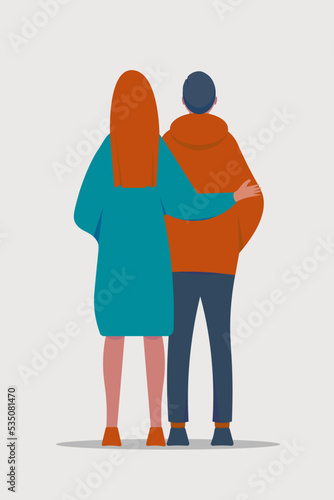 A couple or family, a man and a woman, look ahead to the future, walk along the road, the woman hugs the man