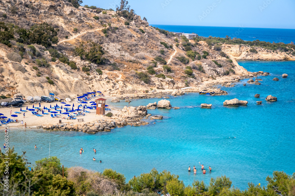 AYIA NAPA, CYPRUS - MAY 01, 2021 The beautiful beach Konnos Bay with turquoise water and tourists who swim and sunbathe