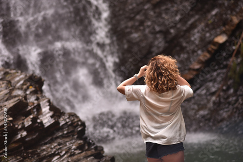 attractive girl on the background of a mountain waterfall