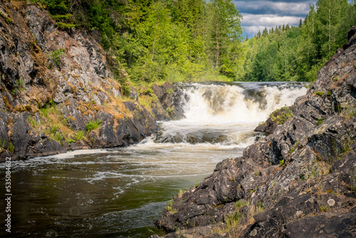 Powerful waterfall Kivach on Suna River, Karelia, Russia. Summer landscape with Karelian forest and river