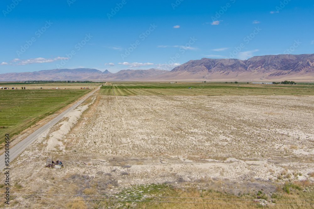 Aerial view of a dirt road running through a valley with alfalfa fields in Northern Nevada. Aerial view of a dirt road running through a valley with alfalfa fields in Northern Nevada.