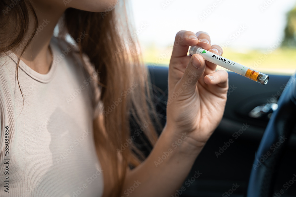 Verification alcoolemie. Ethylotest. Girl driver does alcohol test in the  car, safe driving concept, drugs, drunk driving, negative positive result,  police check, he Stock Photo