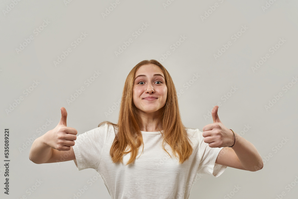 Smiling girl show thumbs up and look at camera Smiling girl show thumbs up and look at camera