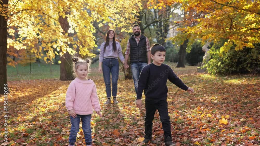Happy children playing with toy airplanes in autumn park, parents looking at them and smiling. Young family enjoy spending time together. Parenthood, carefree childhood, love and happy family concept. Happy children playing with toy airplanes in autumn park, parents looking at them and smiling. Young family enjoy spending time together. Parenthood, carefree childhood, love and happy family concept.