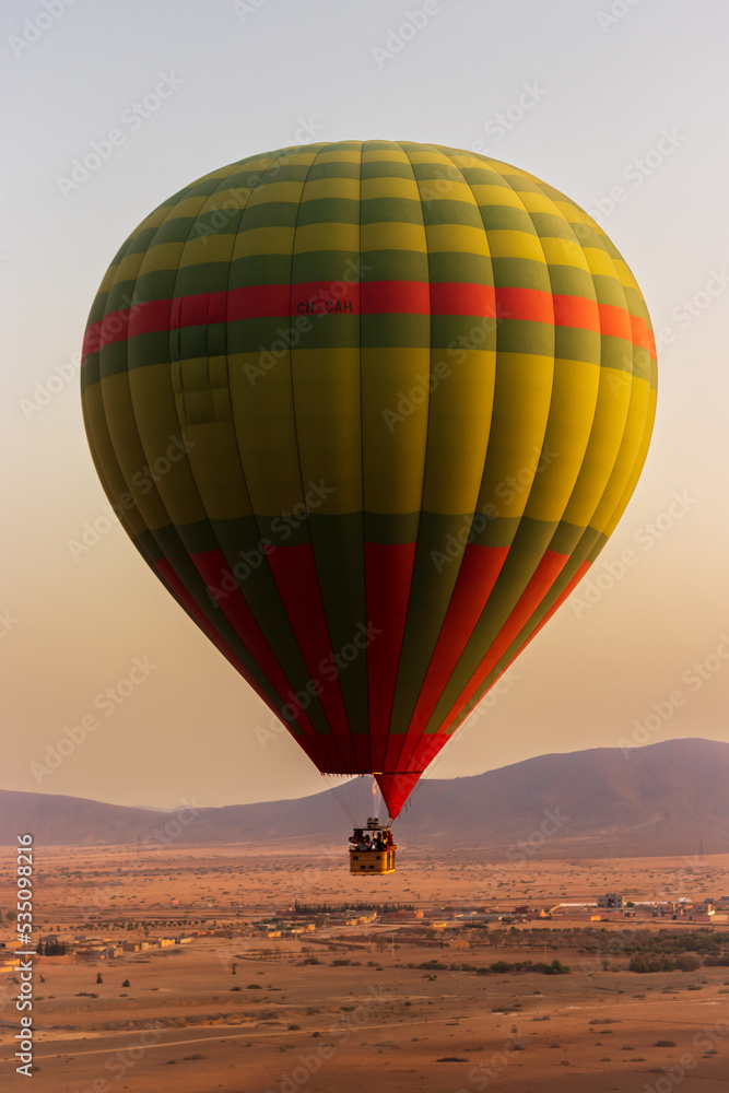 hot air balloon flying over the Moroccan desert and the atlas mountains