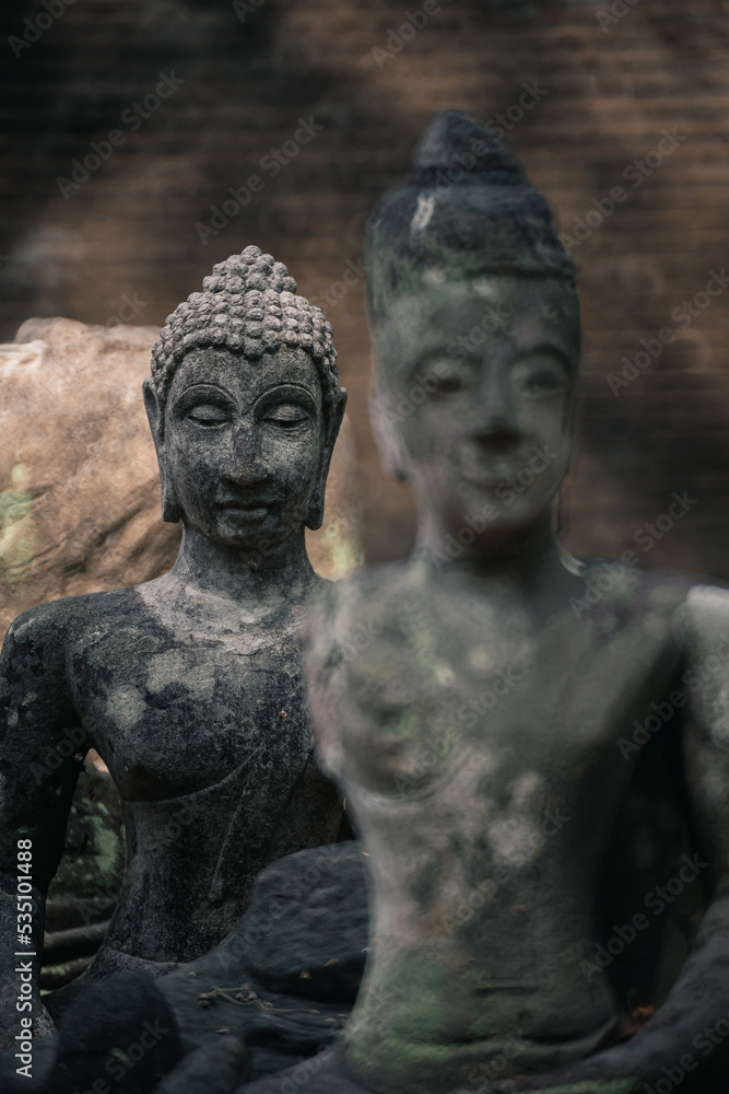 Ancient old ruin Head of Buddha statue carved from sandstone was destroyed and abandoned left in the Wat U Mong Temple. Ancient old ruin Head of Buddha statue carved from sandstone was destroyed and abandoned left in the Wat U Mong Temple.