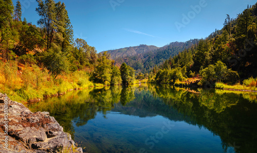 Autumn foliage and tranquil water reflections over the rocky creek on Trinity River near Del Loma  Northern California
