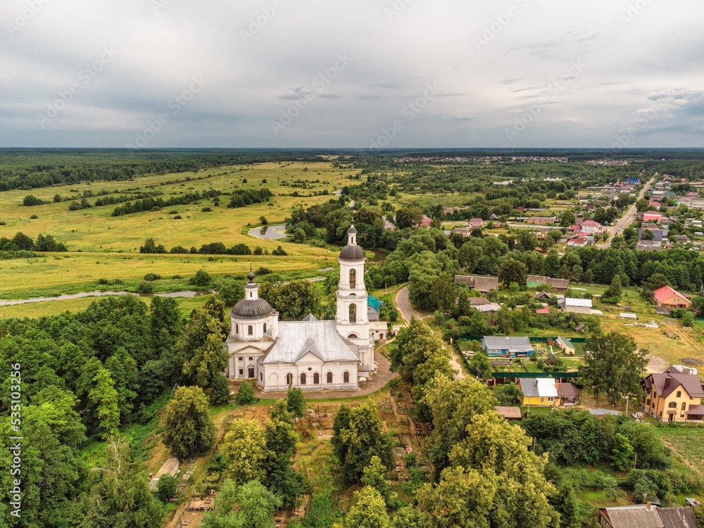 Landscape with orthodox church with fields under gloomy sky