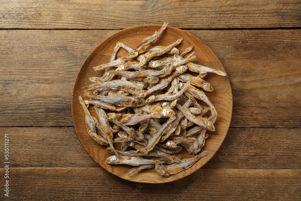 Delicious dried anchovies on wooden table, top view Delicious dried anchovies on wooden table, top view