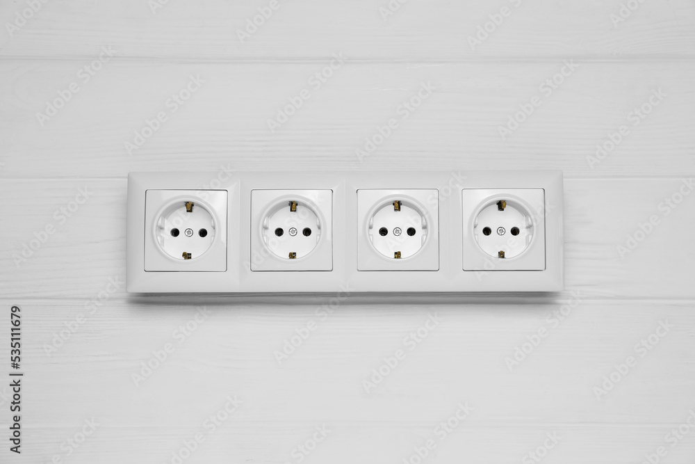 Modern plastic power socket on white wooden table, top view Modern plastic power socket on white wooden table, top view
