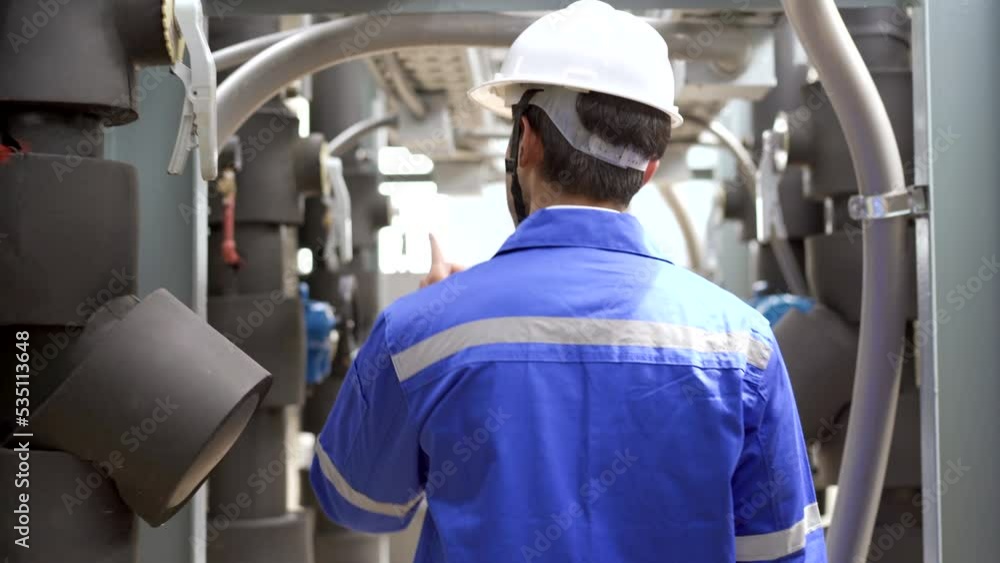 Building system engineer inspecting or checking an air compressor on the building rooftop. Building system engineer inspecting or checking an air compressor on the building rooftop.