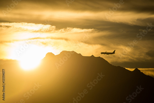 Backlight photography of an airplane flying over the Iztaccihuatl at sunrise, one of the highest mountains in Mexico.  photo