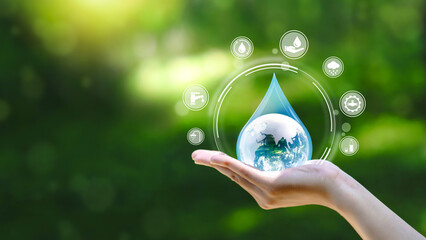 Water drop in hand against natural background in Save water concept on world water day. Conserving the environment in terms of water resources