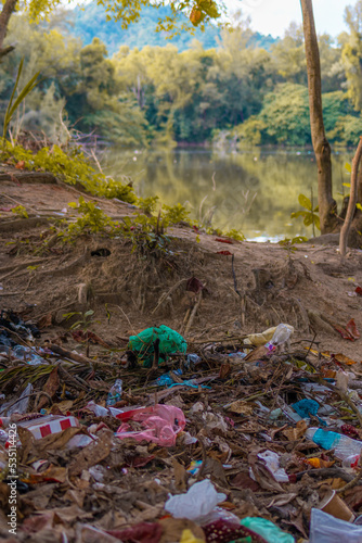 Fototapeta Naklejka Na Ścianę i Meble -  Garbage waste disposal by the lakeside. Environmental Pollution. Global Warming. Save Earth
