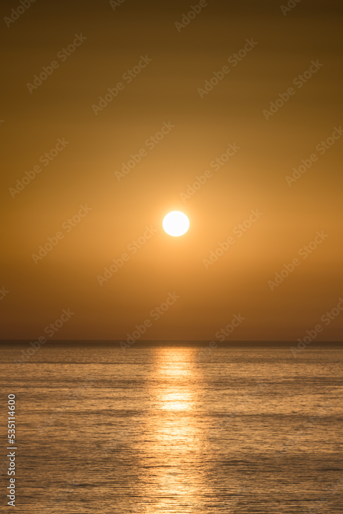 golden shining sun over sea with background of golden sky