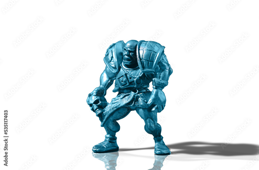 Figurine of an aggressive and vicious bald warrior in armor with a skull isolated on a white background with reflection and shadow added Figurine of an aggressive and vicious bald warrior in armor with a skull isolated on a white background with reflection and shadow added