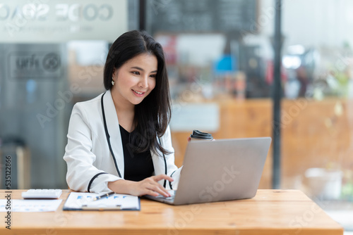 Asian woman working with laptop in her office. business financial concept.