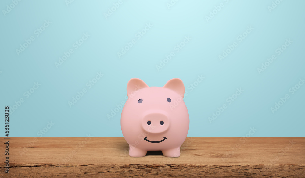 Piggy bank on a wooden table with blue background. saving money and invest concept. Piggy bank on a wooden table with blue background. saving money and invest concept.