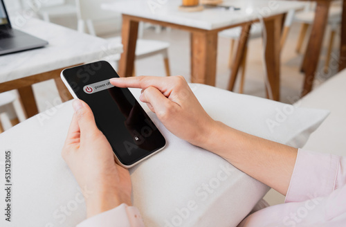 Принти на полотні Woman hand using is sliding to turn off the mobile phone to reduce power consumption