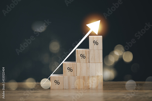 Interest rate financial and mortgage rates concept. Wooden blocks with Icon percentage symbol and arrow pointing up. The economy is improving.