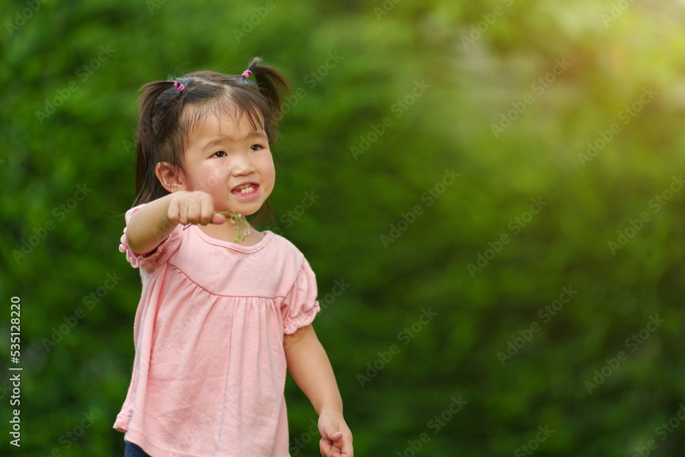 cheerful toddler girl playing grass flower in field cheerful toddler girl playing grass flower in field