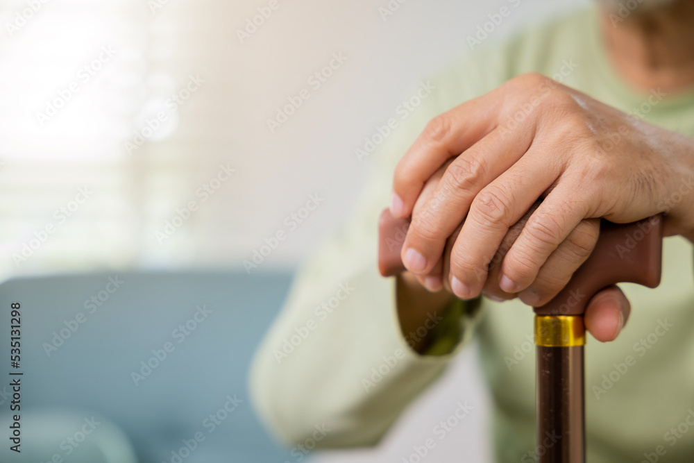 Closeup hands of senior disabled man holding walking stick, Old man sitting  resting on sofa hold wooden walking cane, Elderly hand holding handle of  cane, International Day for the Elderly Photos