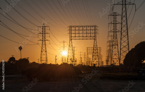 Bild auf Leinwand A maze of electrical transmission wires and towers in front of a golden sunset