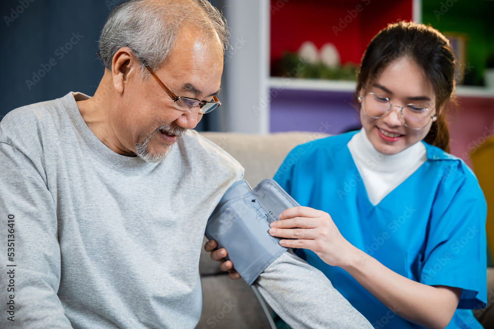 Obraz premium Asian nurse visit patient senior man at home she measuring arterial blood pressure on arm in living room, Doctor woman examine do checking old man client heart rate with pulsimeter monitor, Healthcare