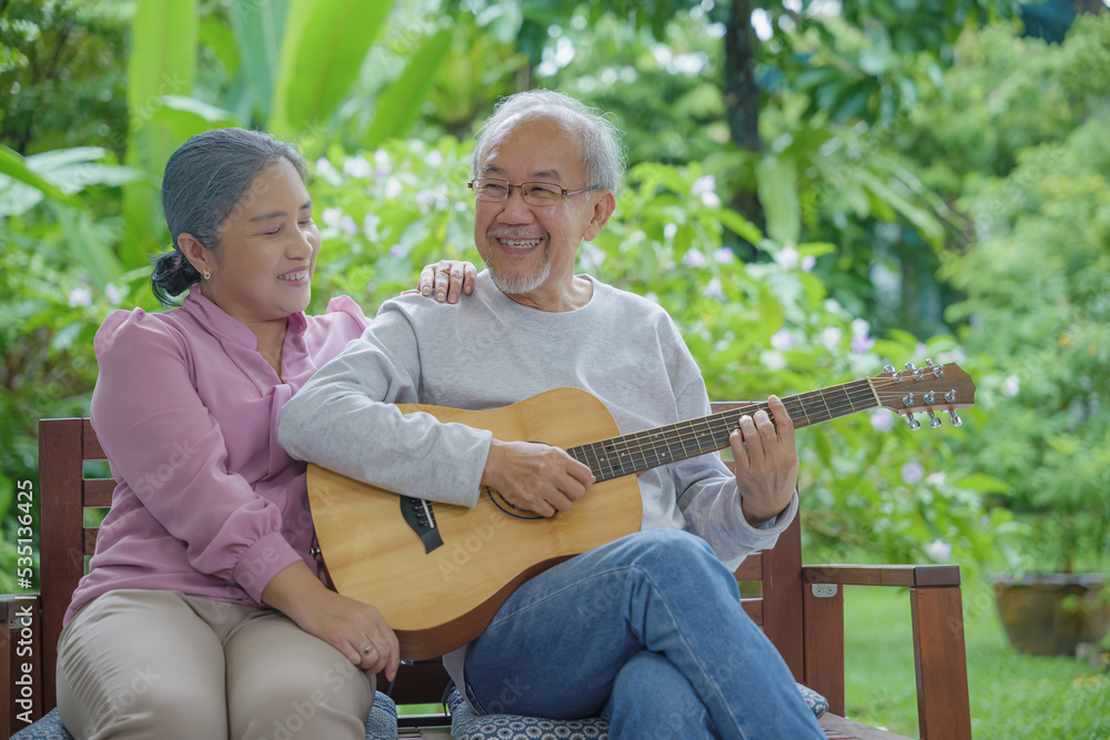 Happy Asian senior couple elderly man playing guitar while his wife singing together outdoors at home, Activity family health care, Enjoying lifestyle during retirement life having fun of senior older Happy Asian senior couple elderly man playing guitar while his wife singing together outdoors at home, Activity family health care, Enjoying lifestyle during retirement life having fun of senior older