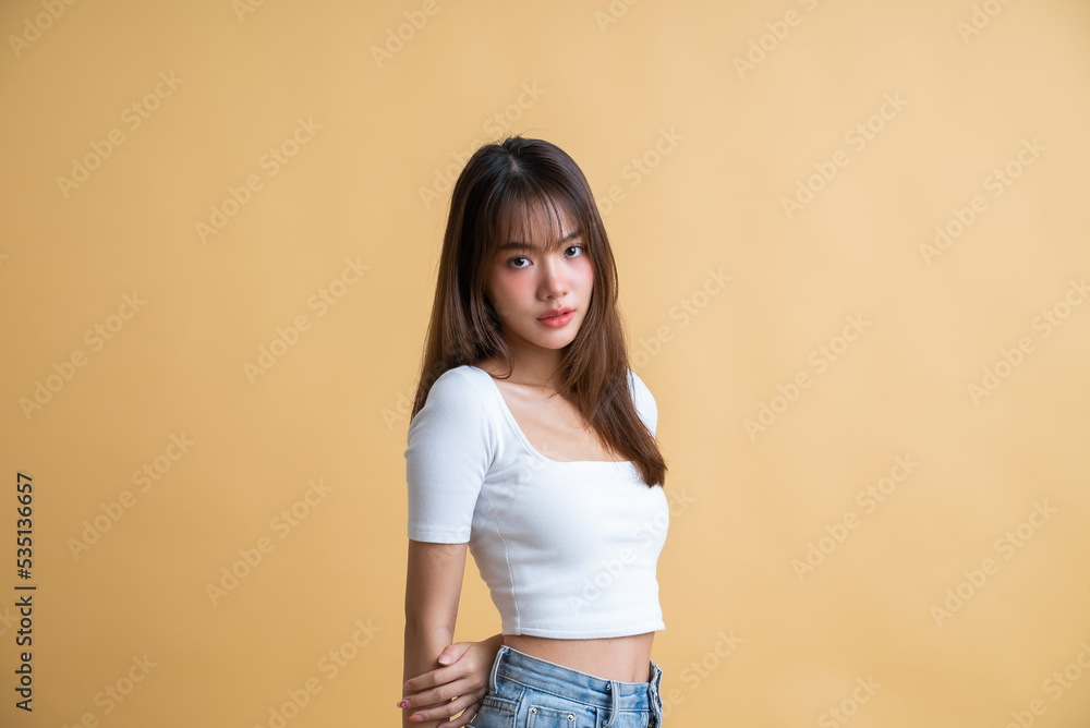 Young attractive Asian woman wearing white t-shirt isolated on yellow background Young attractive Asian woman wearing white t-shirt isolated on yellow background