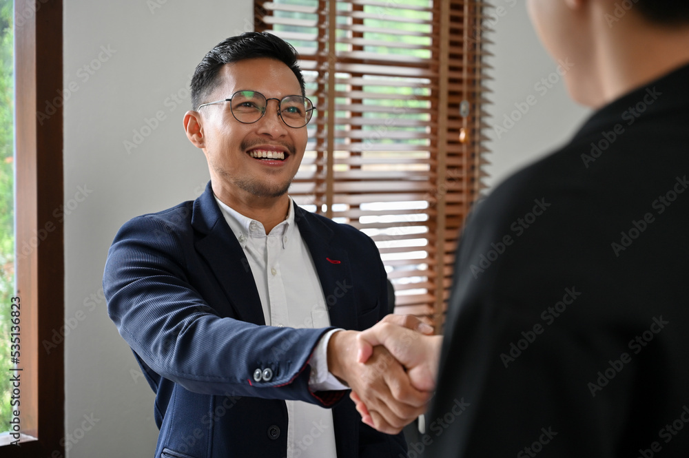Fototapeta premium Successful Asian businessman shaking hand with his business partner in the meeting.